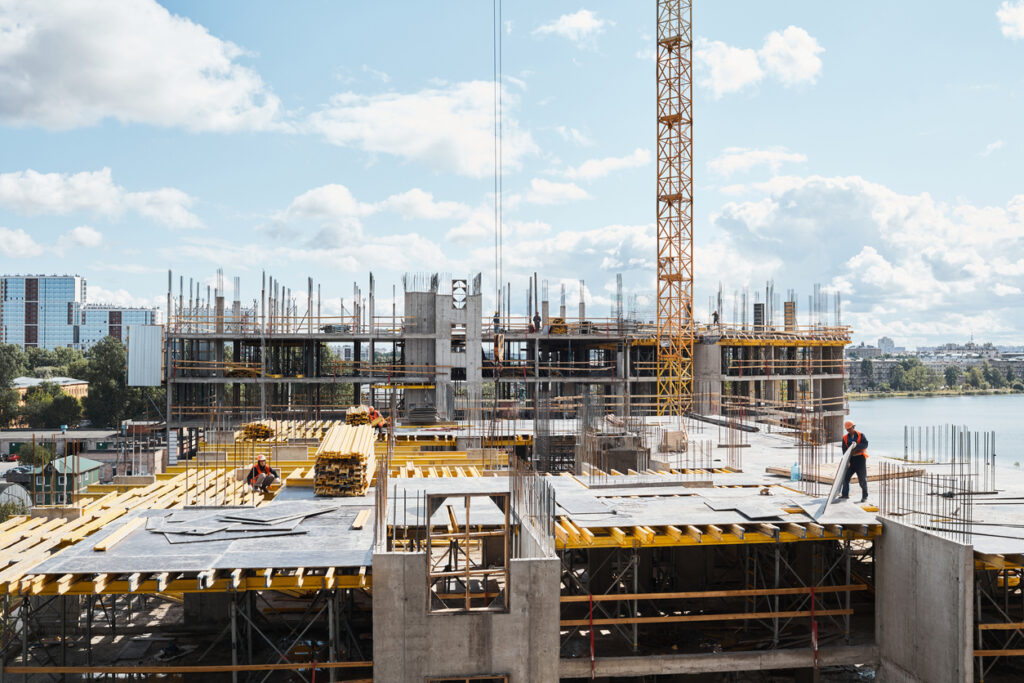 Wide angle view at construction site with unfinished residential buildings against blue sky, copy space